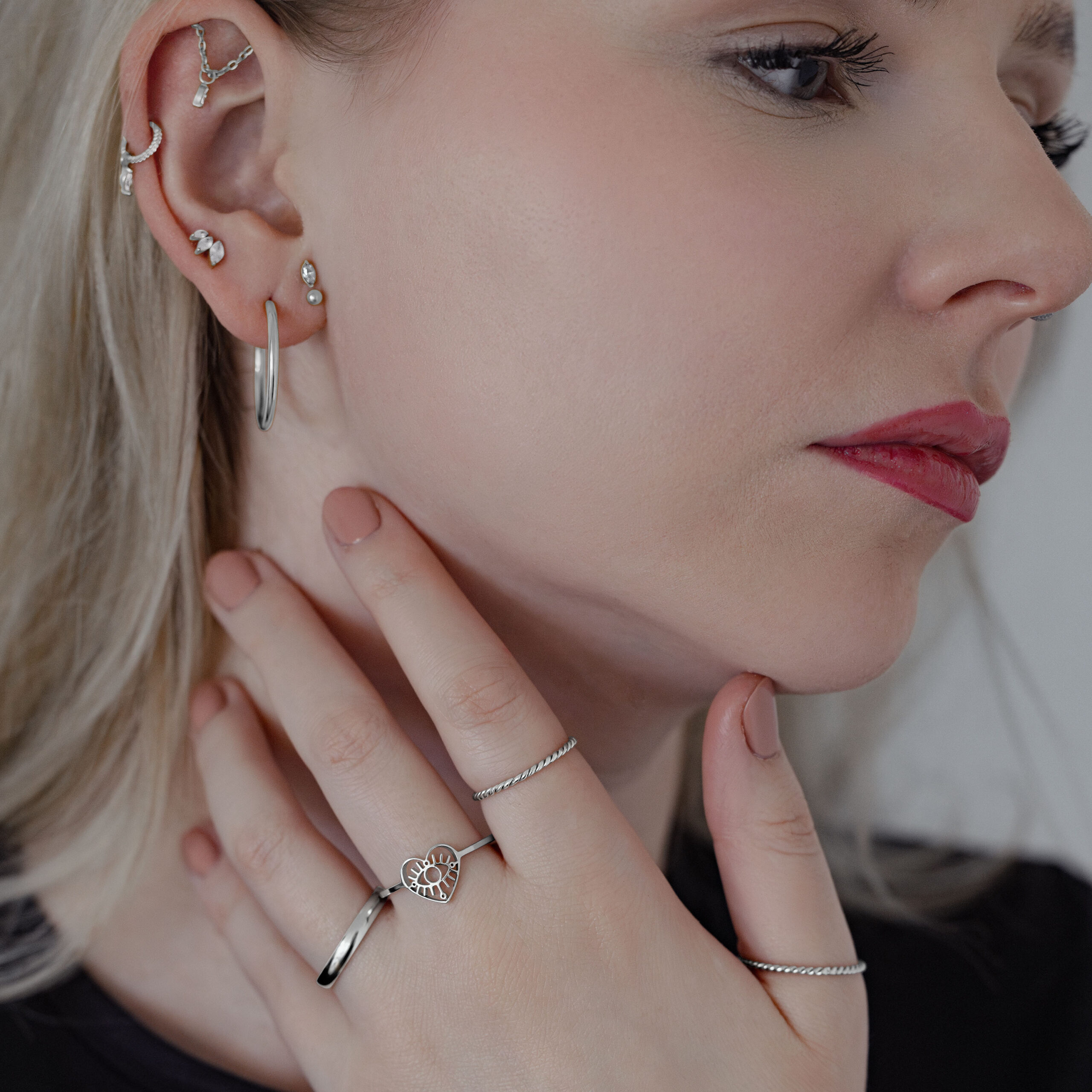 Donna con diversi orecchini che indossa un Twisted Ring in argento