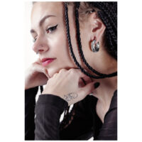 Donna con capelli intrecciati indossa pesi per orecchie Twisted in argento e eyeliner nero