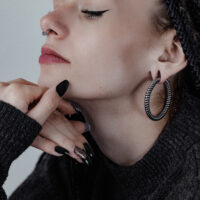 Donna con grandi pesi per orecchie Twisted Rope neri e maglione scuro