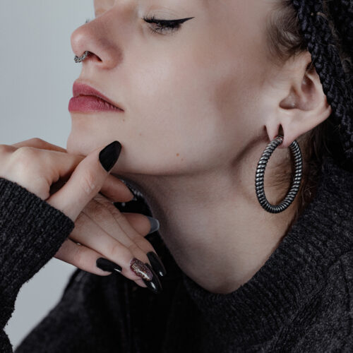 Donna con grandi pesi per orecchie Twisted Rope neri e maglione scuro