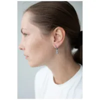 Donna con orecchini d'argento a forma di orsetto gommoso, profilo laterale