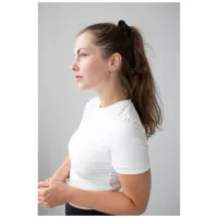 Donna con capelli lunghi indossa cerchietti a spillo neri su sfondo grigio