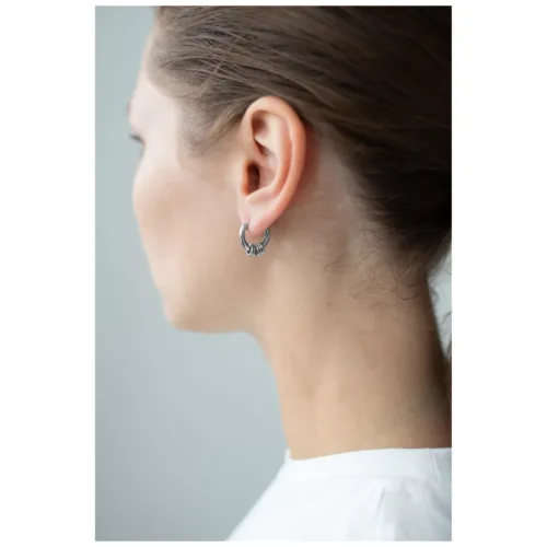 Orecchini in argento con cinque anelli su un orecchio, vista laterale