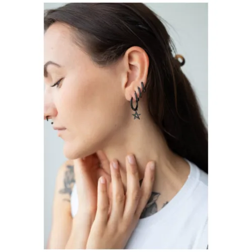 Donna con orecchini a cerchio pentagramma neri in acciaio inox su sfondo chiaro