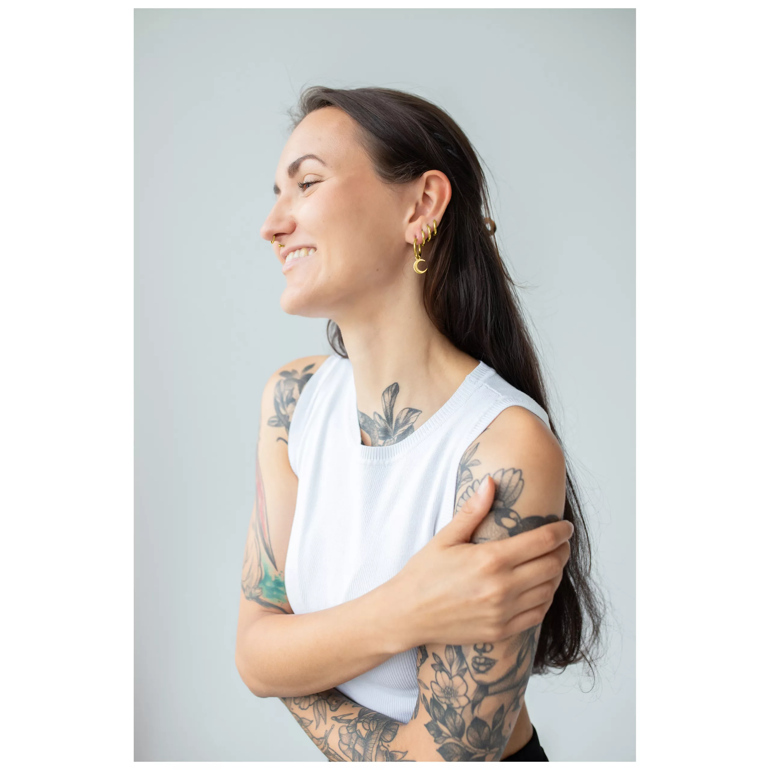 Donna con orecchini gold Little Moonchild Hoops e tatuaggi, sorridente