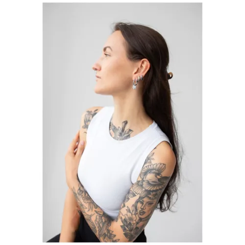 Donna con capelli lunghi indossa stilvolle Little Flower Hoops Orecchini su sfondo grigio