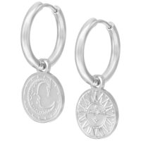 Orecchini argentati con ciondoli di sole e luna su sfondo bianco