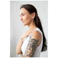 Donna con lunghi capelli scuri indossa i Little Palm Tree Hoops in argento
