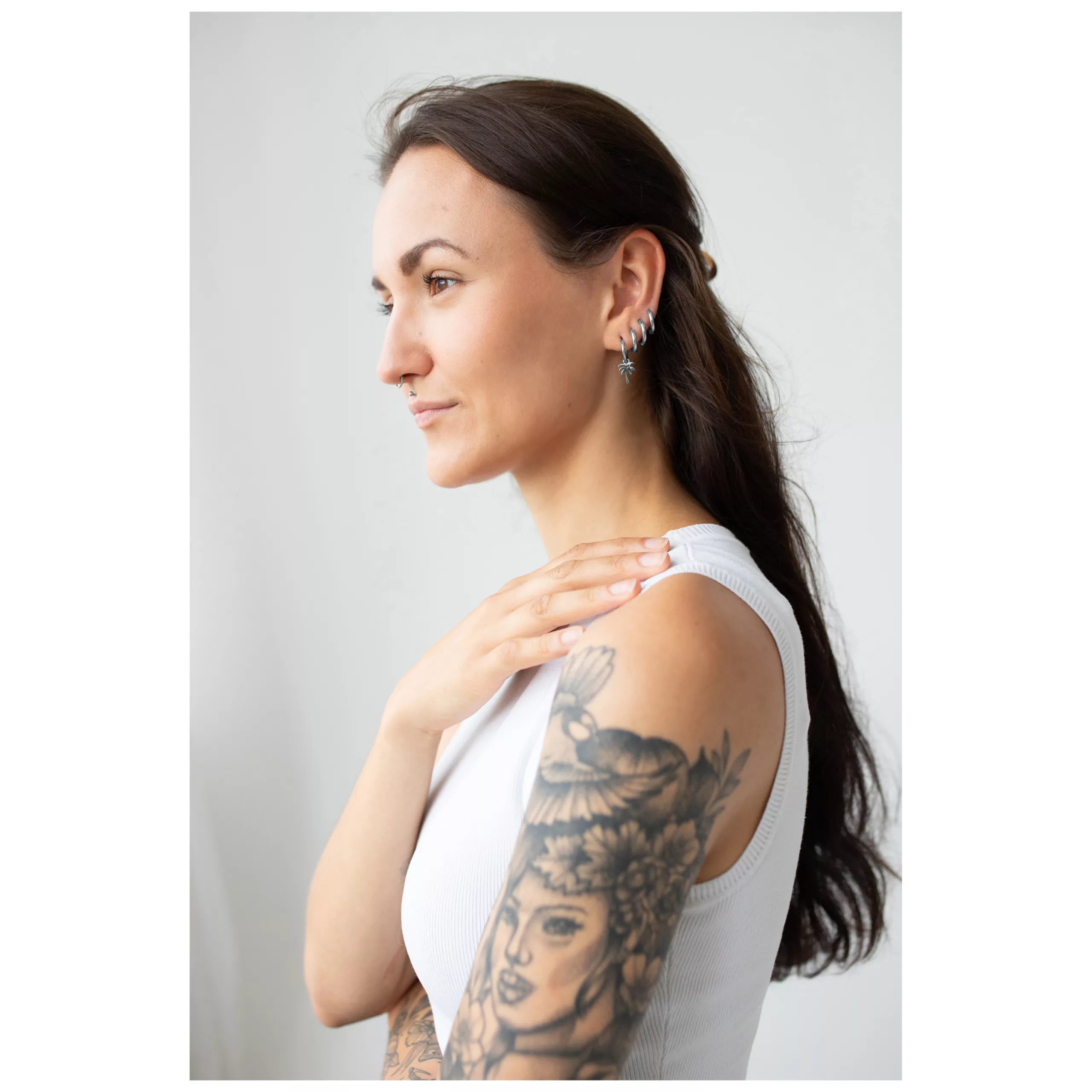 Donna con lunghi capelli scuri indossa i Little Palm Tree Hoops in argento