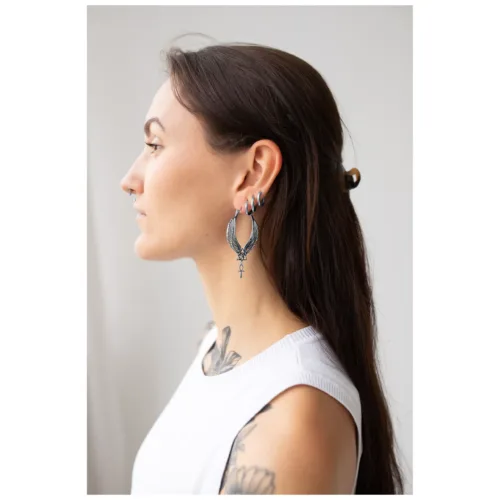 Donna con lunghi capelli scuri indossa grandi orecchini Cleopatra Hoops in argento