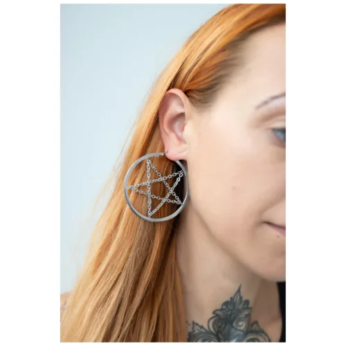 Orecchini pentagramma in argento con catena, indossati all'orecchio, sfondo chiaro