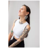 Donna con capelli lunghi indossa i vistosi Thunderflash Eye Hoops, top bianco