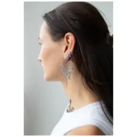 Giovane donna con capelli lunghi indossa grandi orecchini Oracle Hoops neri di profilo