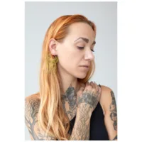 Orecchini Moth Chain Hoops dorati indossati all'orecchio Donna con orecchini Moth Chain Hoops dorati su sfondo neutro