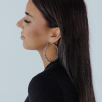 Donna con capelli lunghi indossa orecchini a cerchio Curbchain dorati