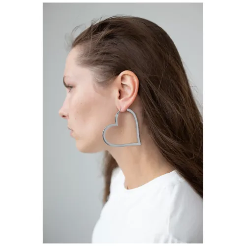 Donna con orecchini a forma di cuore in argento, profilo laterale