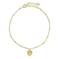 Cavigliera dorata con ciondolo Monstera su sfondo bianco