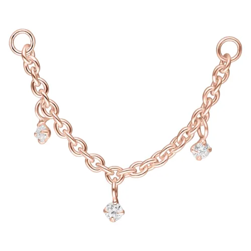 Catena piercing in oro rosa con tre pendenti di cristallo chiaro su sfondo bianco
