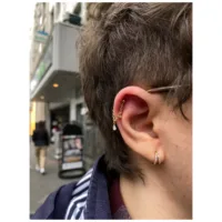 Anello piercing dorato con cristalli all'orecchio in ambiente urbano