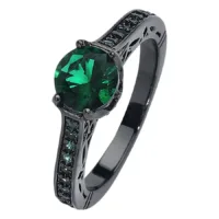 Anello nero in acciaio chirurgico con cristallo verde smeraldo su sfondo bianco