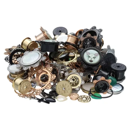 Vari set di piercing in acciaio chirurgico 316L in oro, nero e argento su sfondo bianco