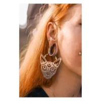 Orecchini Sphynx Hoops in argento su un orecchio con capelli rossi sullo sfondo