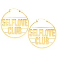 Orecchini dorati Selflove Club Hoops su sfondo bianco