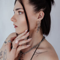 Donna con orecchini a cerchio Big Snake in argento, profilo laterale