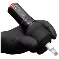 Grip nero per tatuaggi di FK Irons, tenuto da una mano guantata