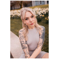 Donna con tatuaggi indossa una catena piercing in argento al parco