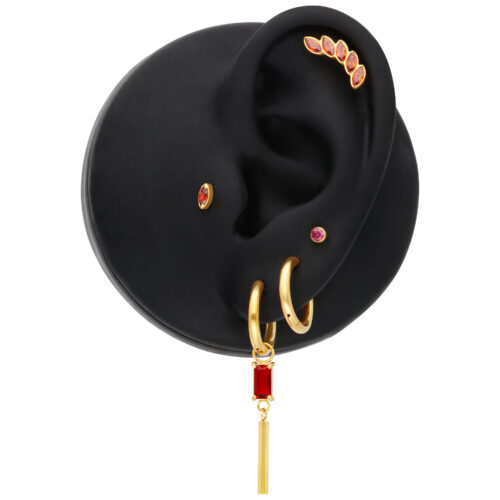 Orecchini dorati con cristallo Siam rettangolare su modello di orecchio nero