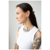 Donna con orecchini Little Polar Star Hoops in oro rosa e braccio tatuato