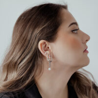 Donna con punta Push Fit in argento nell'orecchio, vista laterale su sfondo bianco