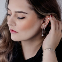 Donna con eleganti Chunky Pearl Hoops neri e argento e altri piercing all'orecchio