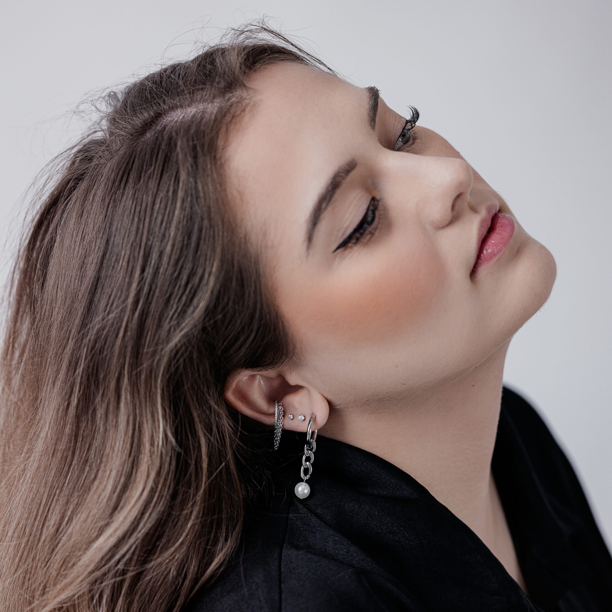 Donna con piercing Clicker Tripla Catena con Cristalli nell'orecchio, su sfondo bianco