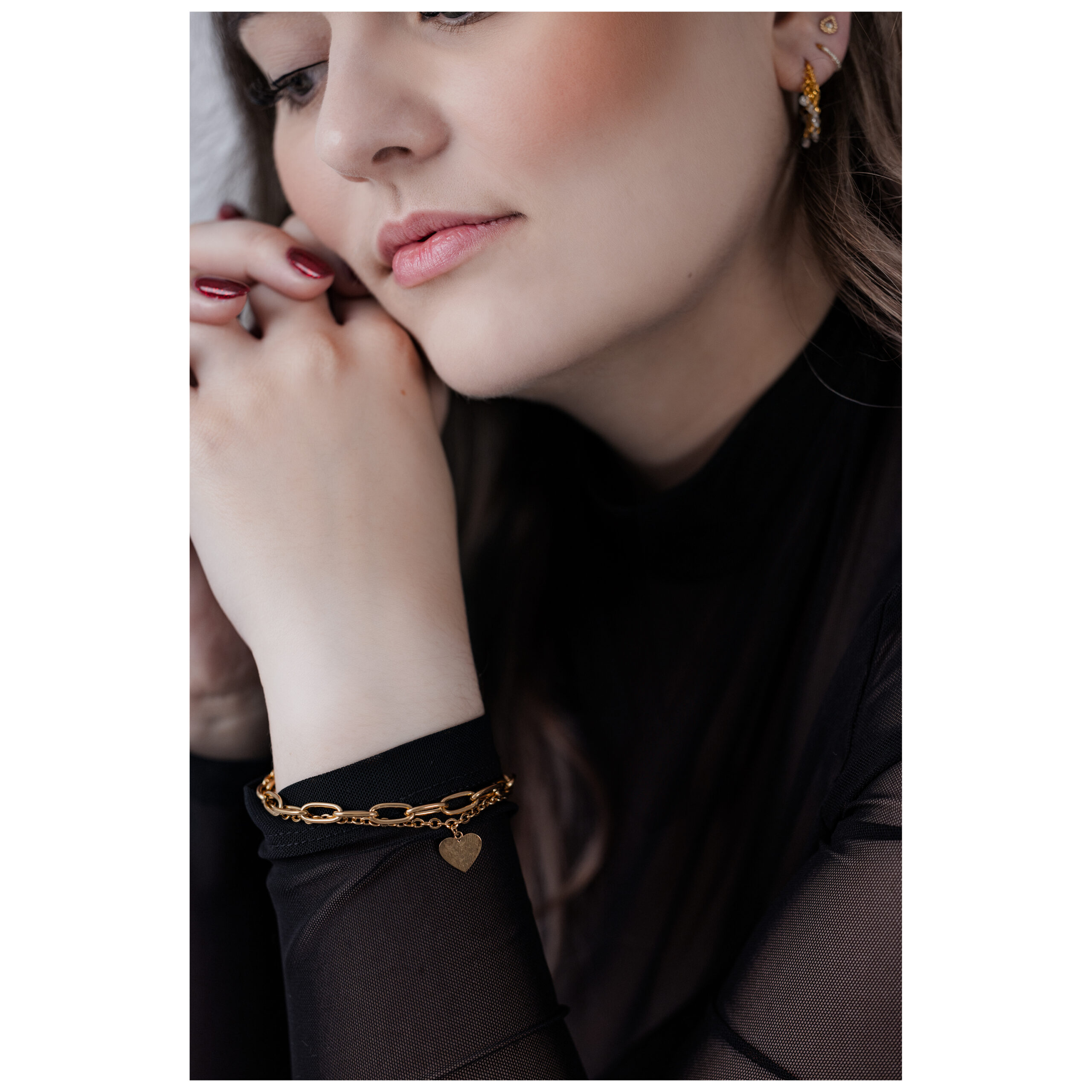 Donna indossa bracciale cuore nero in acciaio chirurgico, elegantemente abbinato
