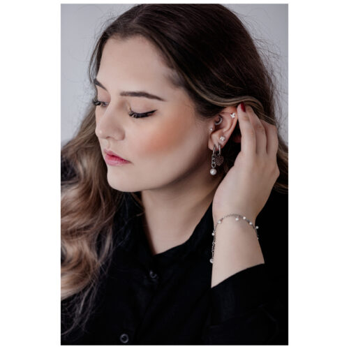 Donna con capelli lunghi indossa un bracciale nero e argento e orecchini