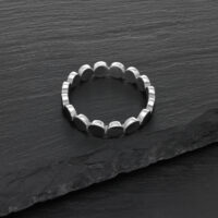 Anello a piastra in acciaio chirurgico argento su sfondo di ardesia nera