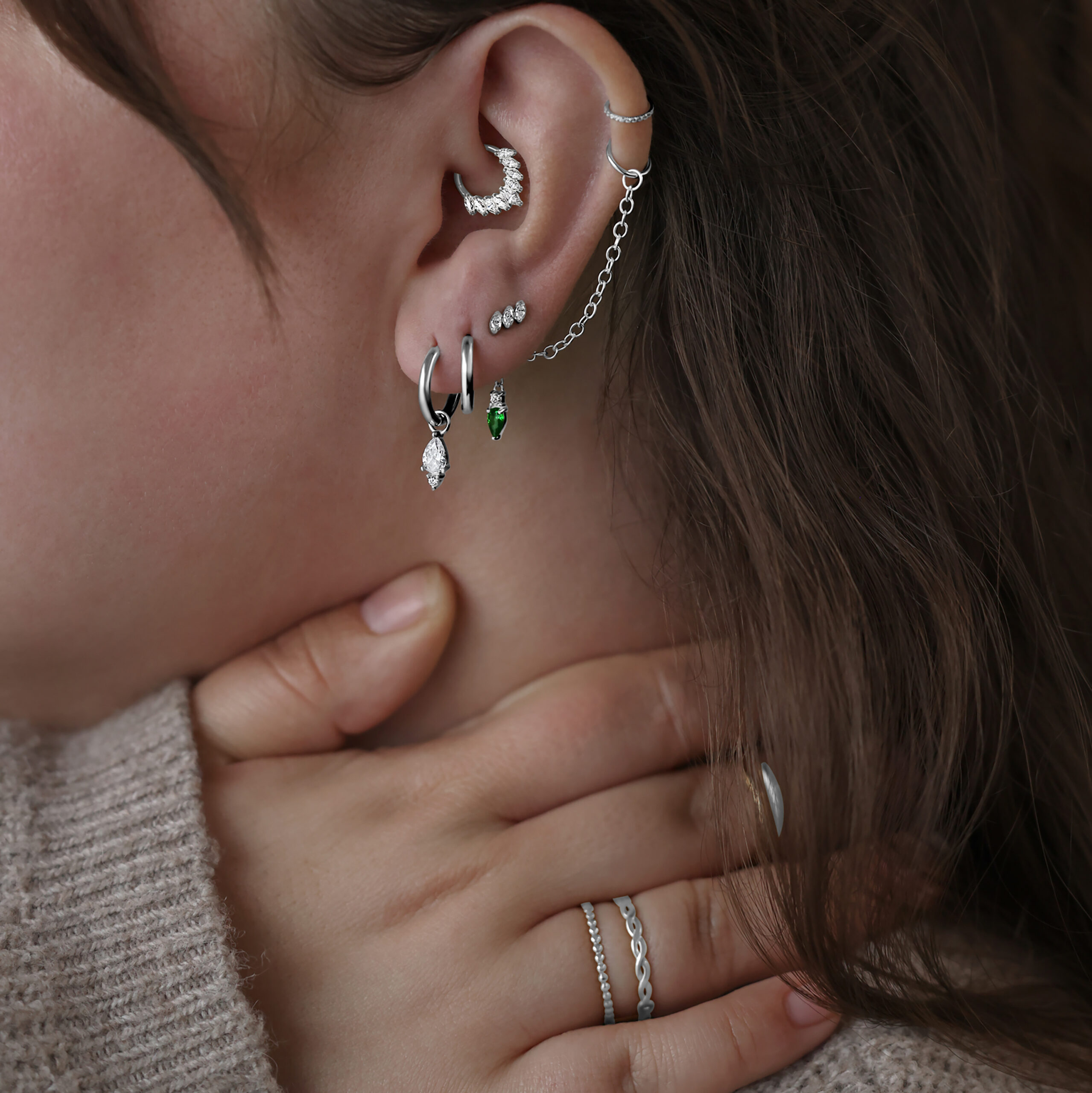 Donna con diversi piercing d'argento all'orecchio, incluso un attacco Gracia