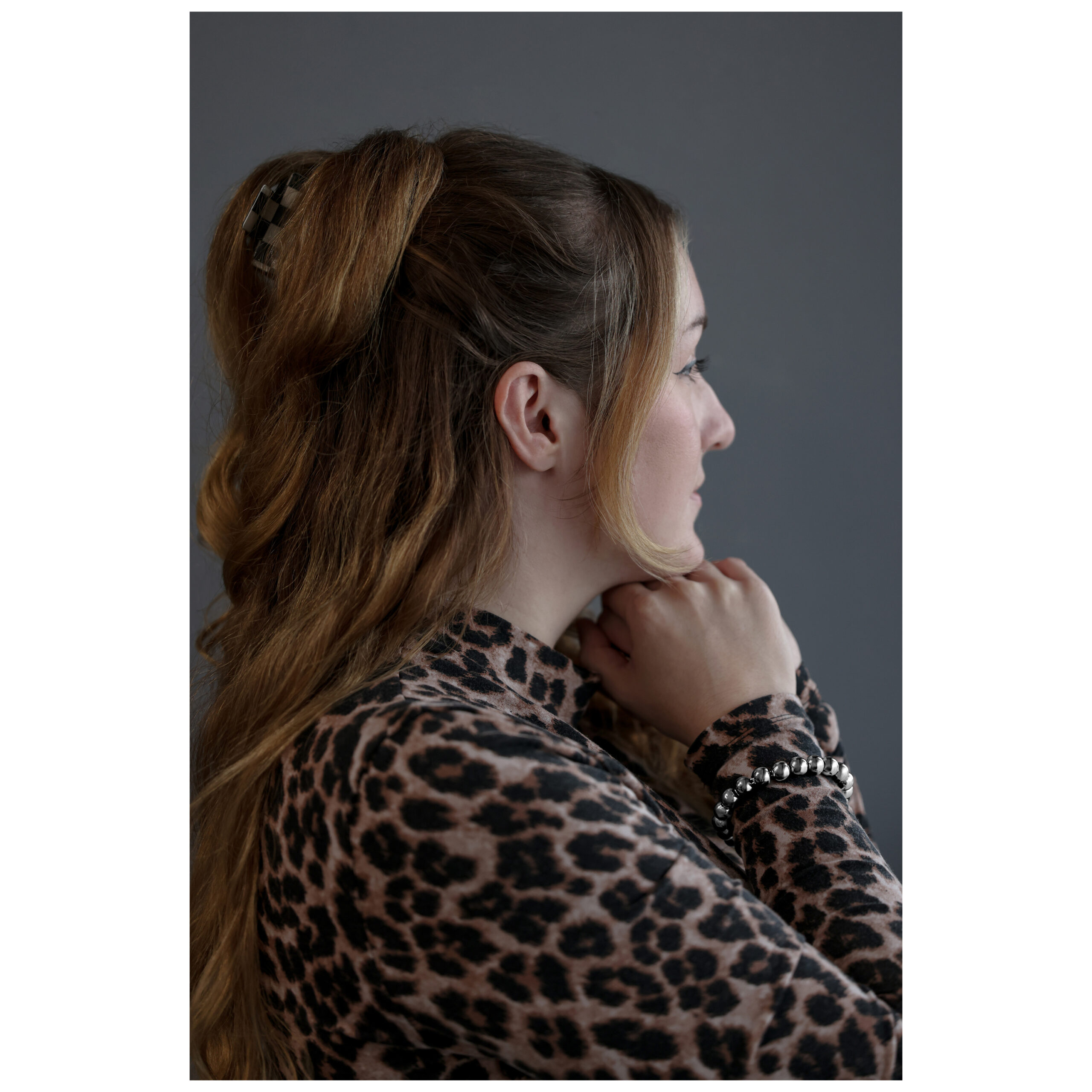 Donna con capelli raccolti indossa un bracciale Bubble color argento su sfondo grigio