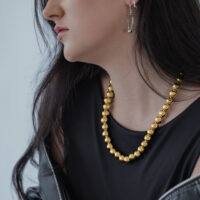 Donna con top nero e collana Bubble dorata di Wildcat