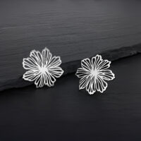 Due orecchini a fiore in argento in acciaio inossidabile su sfondo scuro