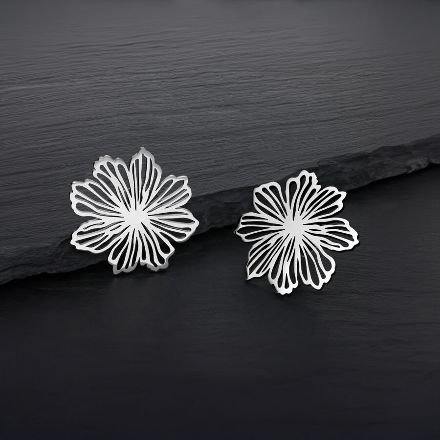 Due orecchini a fiore in argento in acciaio inossidabile su sfondo scuro