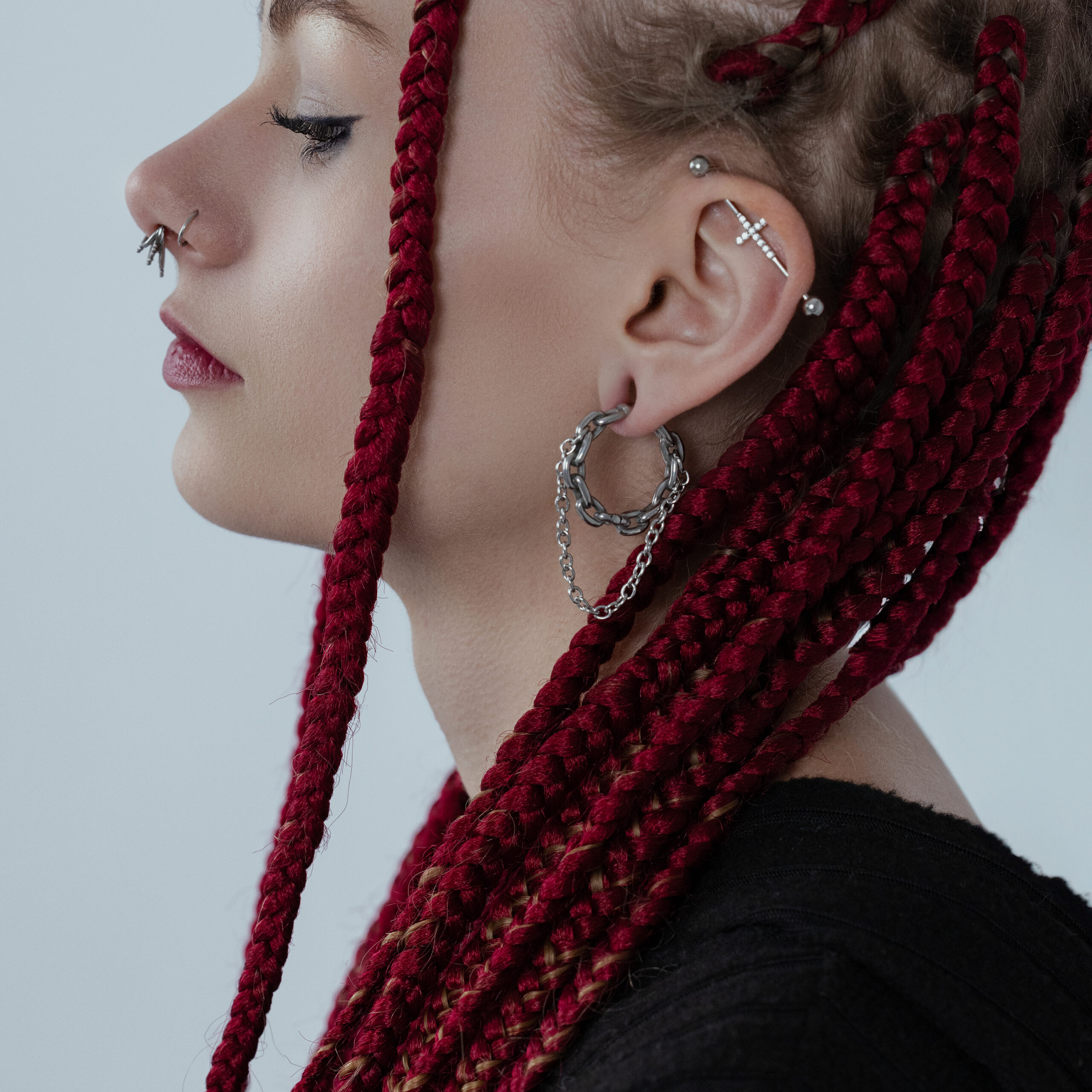 Donna con trecce rosse indossa pesi per orecchie a doppia catena in acciaio chirurgico argentato