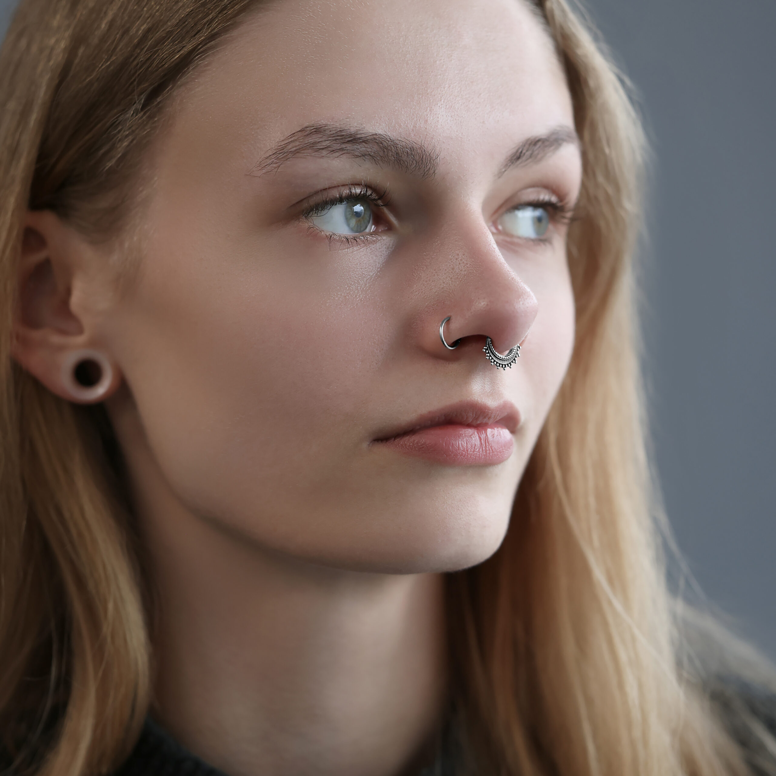 Donna con septum clicker in argento di Wildcat, sfondo grigio