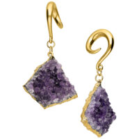 Pesi per orecchie in oro con ametista e cristalli Pesi per orecchie in metallo dorato con cristalli di ametista viola su sfondo bianco