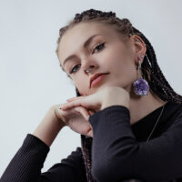 Donna con peso per orecchie in ametista in acciaio chirurgico argentato e piercing