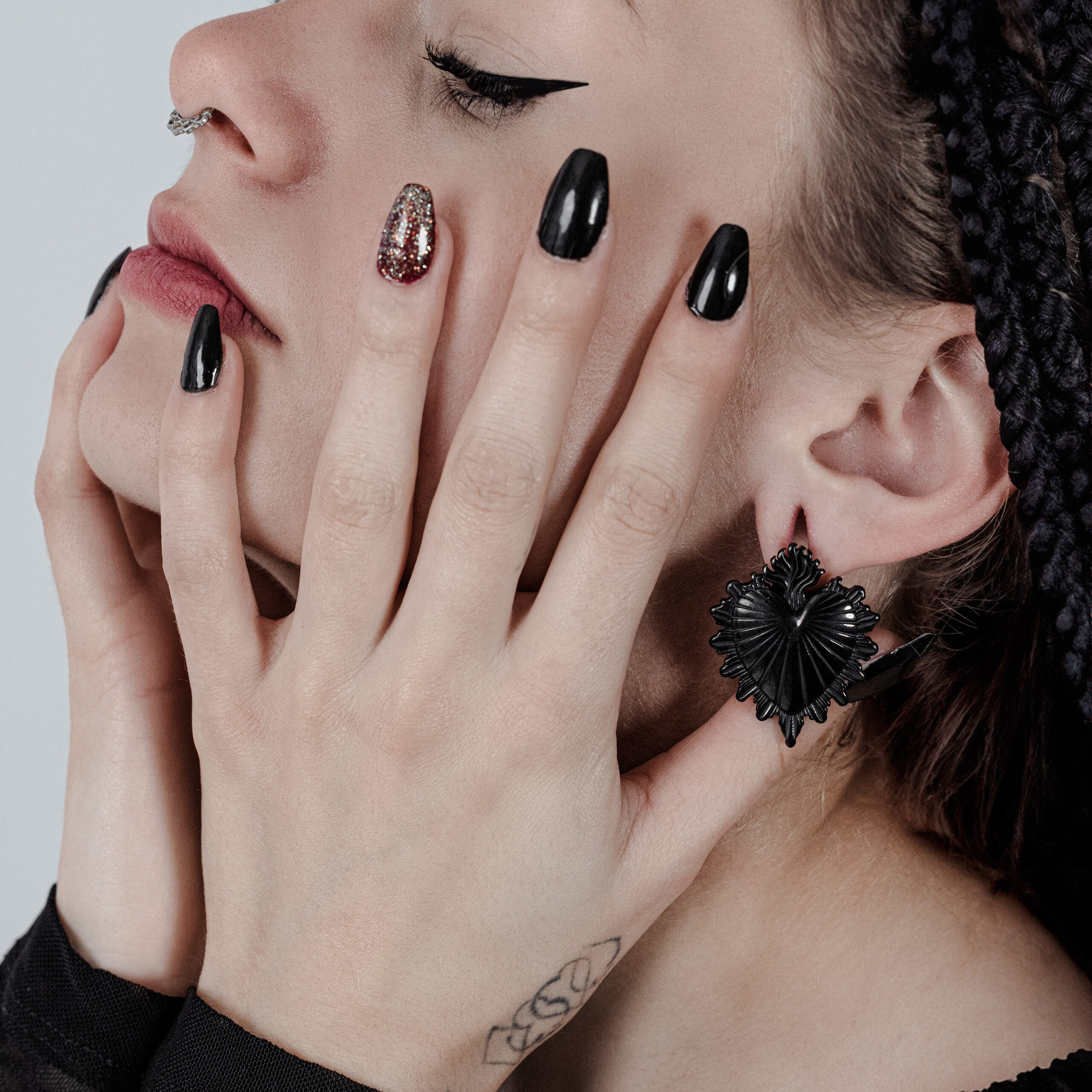 Donna con pesi per orecchie Sacred Heart neri e smalto nero, vista laterale