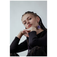 Donna con treccia indossa grandi pesi per orecchie in oro con ametista