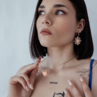 Donna con collana basic incidibile in oro rosa su sfondo chiaro